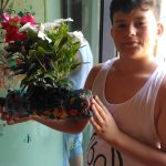 CasaOz - bambino mostra fiero una fioriera realizzata al laboratorio di giardinaggio