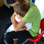 CasaOz - un'educatrice abbraccia teneramente un bambino